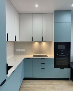 an empty kitchen with blue cabinets and white counter tops, including a stove top oven