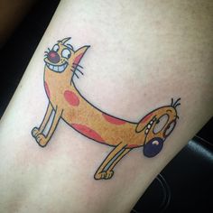 a cartoon character tattoo on the leg of a woman's leg, with an orange cat