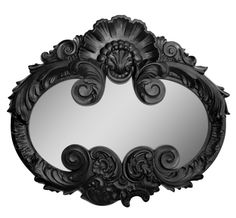 a mirror with an ornate design in the shape of a bat