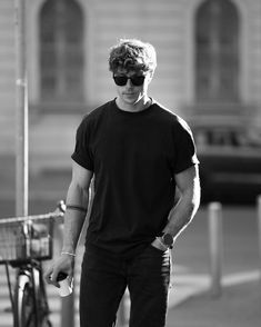 a man in black shirt and sunglasses riding a skateboard