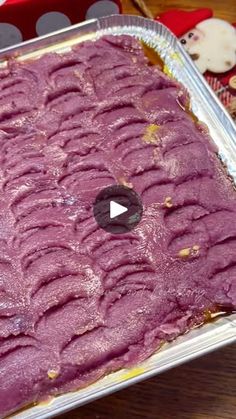 a pan filled with purple cake sitting on top of a wooden table