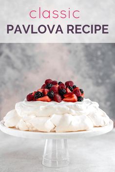 a cake with whipped cream and fresh berries on top is sitting on a glass pedestal