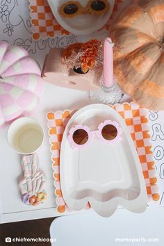 a table topped with plates and glasses next to other items on top of a checkered table cloth