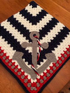 a crocheted blanket with an anchor on it