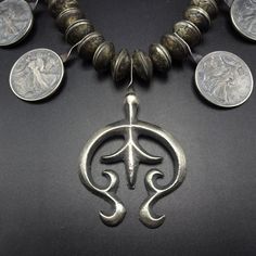 "VINTAGE NAVAJO MERCURY DIME & STANDING LIBERTY COIN SILVER NECKLACE DESCRIPTION: This outstanding necklace features 48 Mercury Dime beads (for a total of 96 dimes), and 8 well-defined Standing Liberty half dollar coins (1936, 1941, 1942, 1943, 1944 x 2, 1945, 1946). The sand cast naja features fleur de lis and flared terminal. This impressive old necklace will be a valuable addition to your collection of fine vintage Native American jewelry. MEASUREMENTS: Necklace measures 21 1/2\" end to e Vintage Coin Necklace With Large Pendant, Symbolic Antique Finish Necklace As Collectible, Symbolic Antique Finish Necklaces For Collectors, Vintage Medallion Coin Necklace, Collectible Spiritual Coin Necklaces, Vintage Coin-shaped Jewelry With Large Pendant, Vintage Oxidized Coin Necklace, Vintage Coin-shaped Large Pendant Jewelry, Vintage Silver Coin Necklace