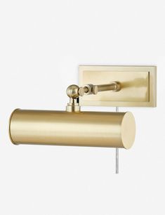 a brass colored wall light on a white background