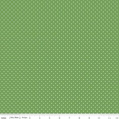 a green background with small white dots on the bottom, and a ruler next to it