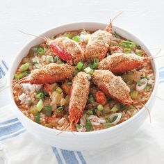 a white bowl filled with seafood and rice on top of a blue and white table cloth