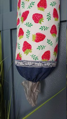 a bag hanging from the side of a door with strawberries on it