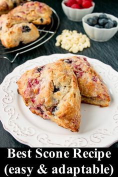 two blueberry muffins on a white plate next to berries and other dessert items