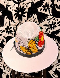 These vibrant hats are hand-painted in Oaxaca, Mexico, with vibrant flowers and a monarch butterfly around the hat's crown. Hat is made of canvas— light and breathable, but durable and waterproof. Elastic band inside the hat crown ensures a snug, secure fit. Adjustable Artisan Sun Hat For Spring, Spring Festival Sun Hat Hand Painted, Spring Festival Hand Painted Sun Hat, Hand Painted Curved Brim Sun Hat For Spring, Hand Painted Sun Hat With Curved Brim For Spring, Hand Painted Brimmed Sun Hat For Spring, Artistic Adjustable Hats For Spring, Hand Painted Fedora For Summer Festivals, Artistic Fedora Sun Hat For Spring