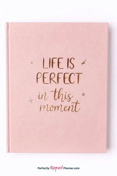 a pink notebook with the words life is perfect in this moment