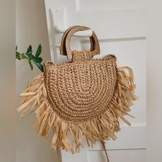 a straw bag hanging from the side of a white door with a plant in it