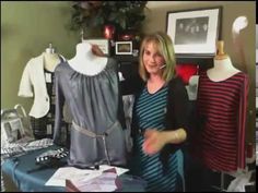 a woman standing next to two dresses on mannequins in front of a table