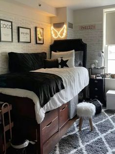 a bedroom with white brick walls, black bedding and gray carpeted flooring