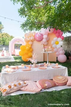 an outdoor party with balloons, cake and desserts