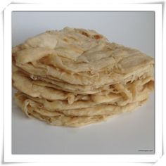 a pile of uncooked bread sitting on top of a white table