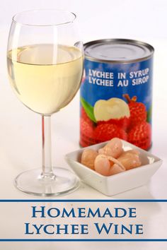 a glass of white wine next to a can of grapes and raspberries with the words homemade lychee wine