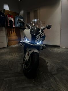 a motorcycle is parked in a room with wood flooring