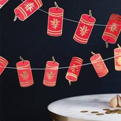 paper lanterns are strung on a string over a table with gold coins and other decorations