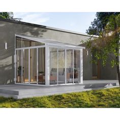 an image of a house that is in the grass with glass walls and doors on it