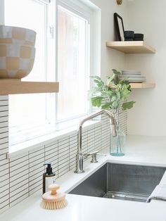 a kitchen sink with a brush and soap dispenser on the counter next to it