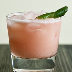 a pink drink with a green leaf garnish on top