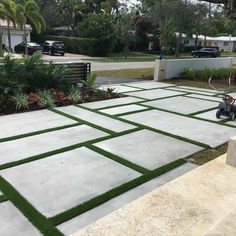 a man sitting on a bench in the middle of a yard with grass growing all over it