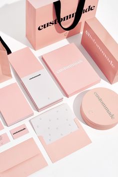 an assortment of pink and white items including a paper bag, notepads, notebooks, and more