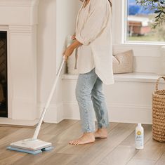 a woman is cleaning the floor with a mop