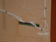 wires are attached to the back of a computer motherboard in an office building with red brick walls