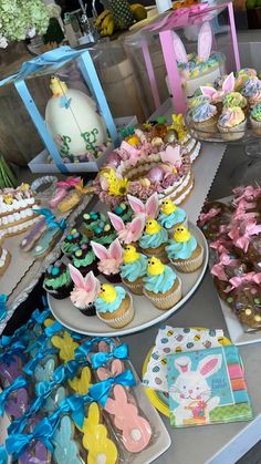 an assortment of decorated cupcakes and cookies on a table