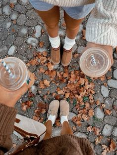 two people standing next to each other with their feet on the ground and one holding a water bottle