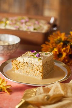 a piece of cake sitting on top of a plate next to a bowl of flowers