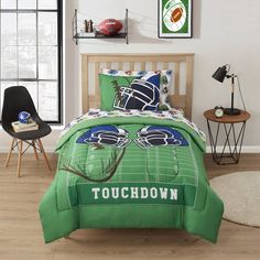 a bed with a football themed comforter and matching pillowcases in a bedroom