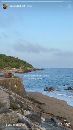 an image of a beach with rocks and the ocean in the background on a cell phone