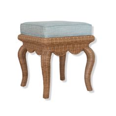 a wicker foot stool with a blue cushion on the top and bottom, against a white background