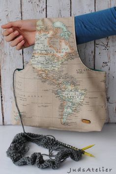 a person is holding a crocheted bag with a map on it and a string attached to it