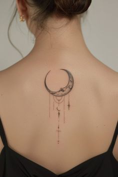 the back of a woman's neck with a crescent and stars tattoo on it