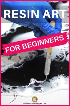 a person in blue gloves is holding a paintbrush over black and white liquid with the words resinin art for beginners