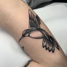 a black and white bird tattoo on the arm