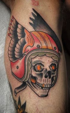 a skull wearing a helmet with wings on it's head and an orange eye