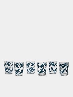 four shot glasses with blue and white designs on them