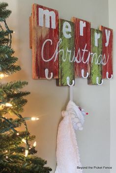 a christmas sign hanging from the side of a wall