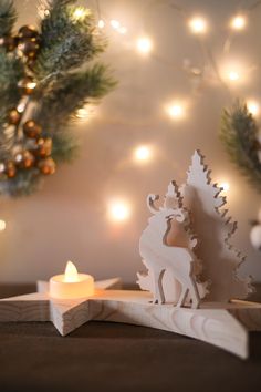 a small wooden deer next to a lit candle