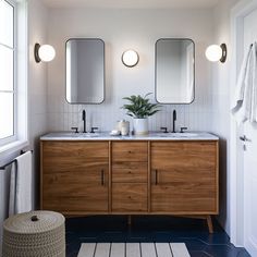 a bathroom with two sinks and three mirrors