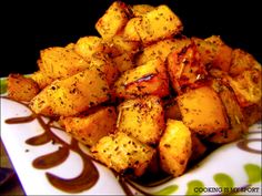 a pile of cooked potatoes on a plate with chocolate sauce drizzled over the top