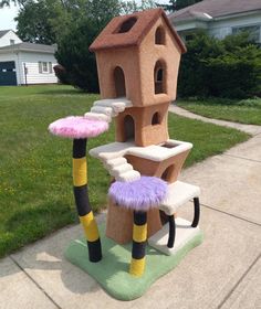 a cat house made out of fake furs on the sidewalk in front of a house