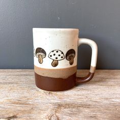 a coffee mug with mushrooms painted on it