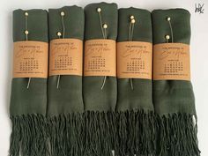 four green scarfs with calendar tags on them